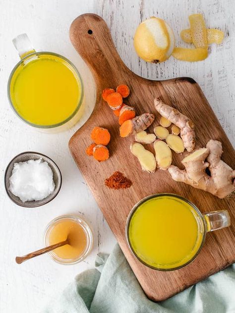 Vue aérienne d'une tasse de bouillon Cooldo avec des éclats de gingembre et de curcuma frais.