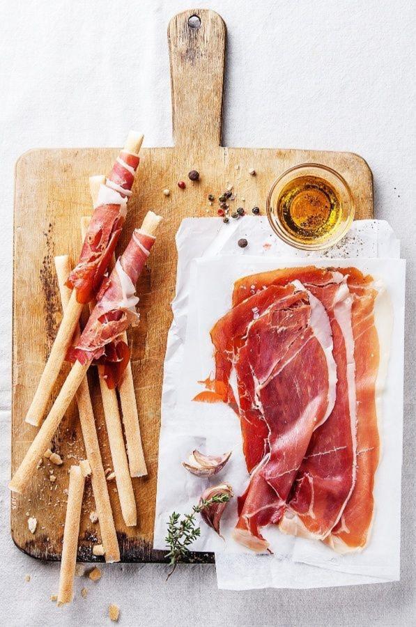 Duo de tranches de jambon Serrano et Bellota pour illustrer la différence de texture et de gras.